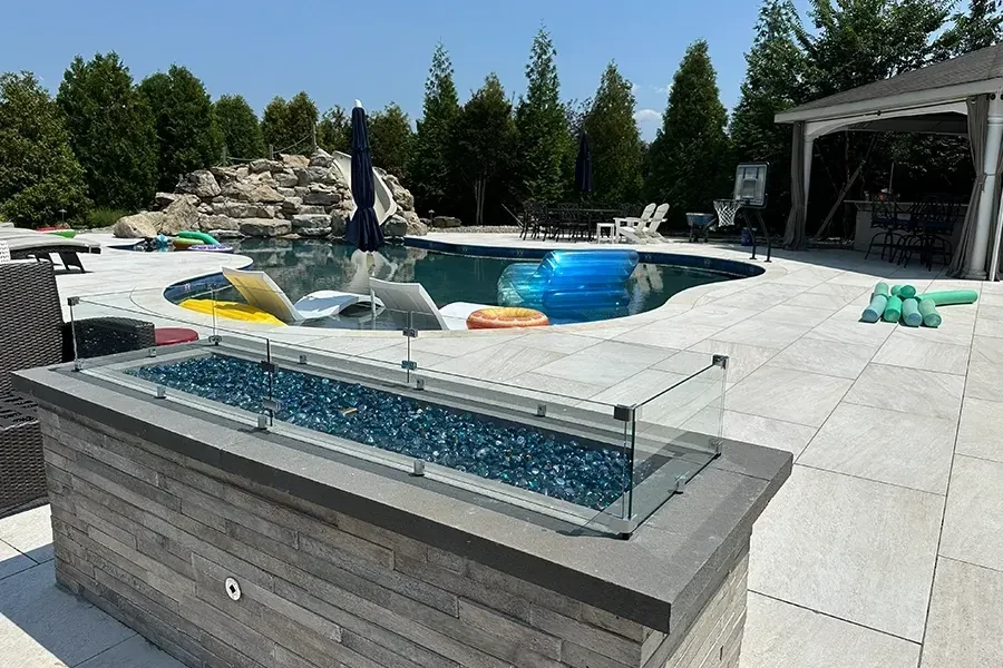 Porcelain poolside patio with raised fire feature